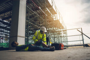 A coworker helps an injured colleague after a fall from scaffolding 