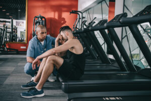 A medical professional is helping a man who has been injured in the gym 