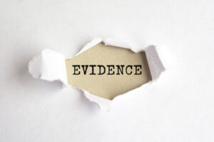 The word 'evidence' appearing behind torn paper. 