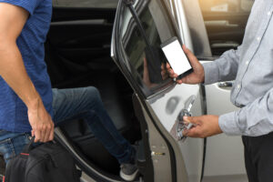 Taxi driver holding a door open for a passenger. 