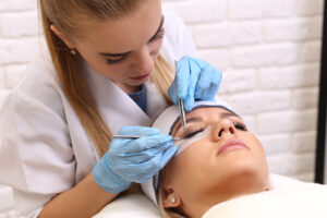 A woman in a beauty salon performing a beauty treatment on eyelashes